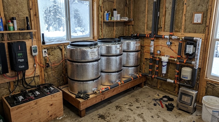 insulated off grid water setup with water barrels